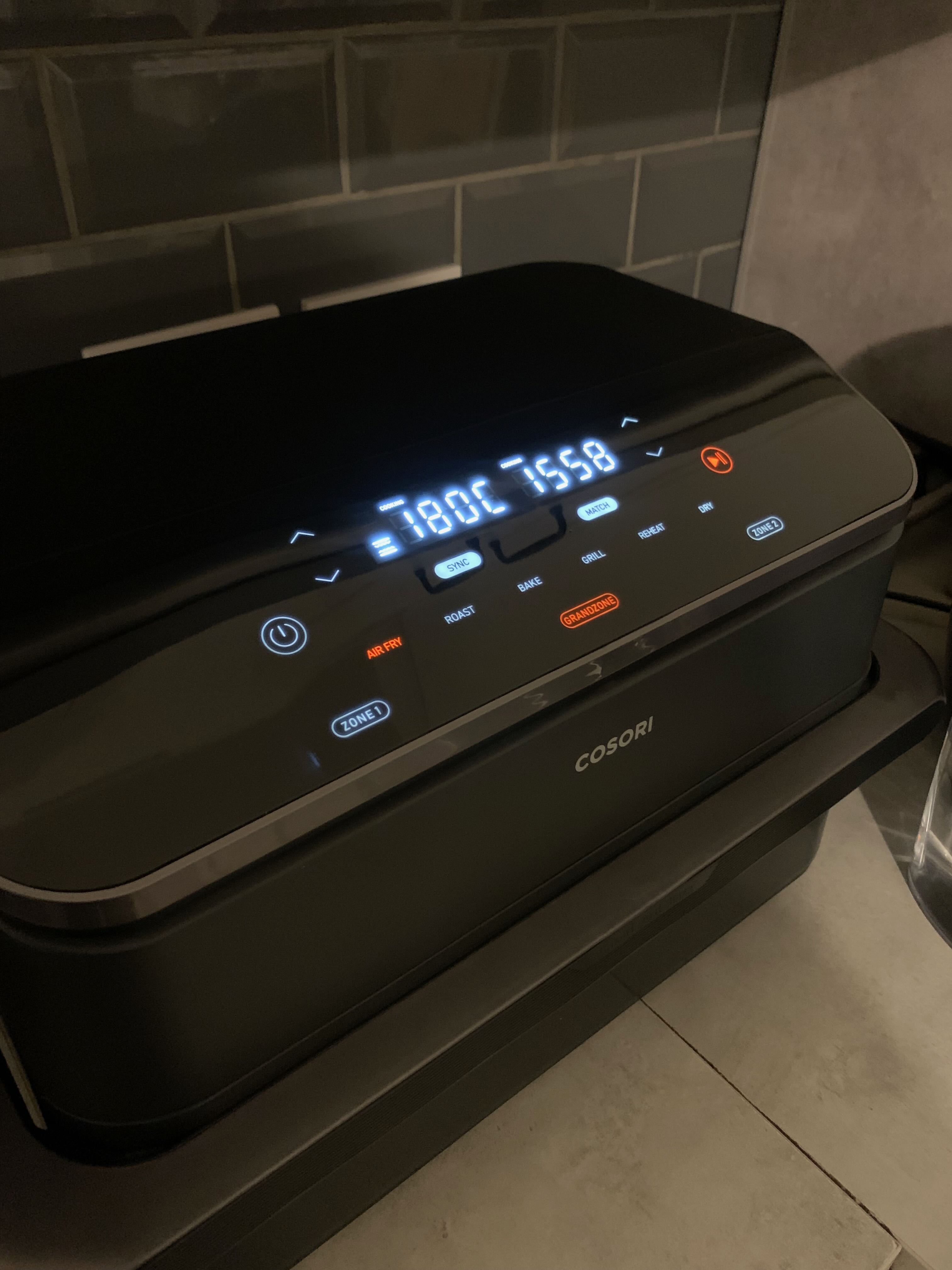 Cosori TwinFry dual-zone air fryer lit up during a cooking session
